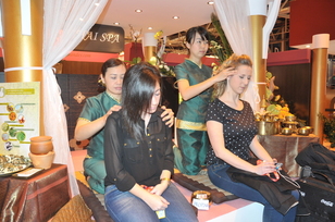 FITUR 2012 dos vistantes se recuperan de las horas de trabajo en la feria mediante masaje tai en el stand de Tailandia.