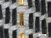Fibras de tejido con sensores de temperatura integrados bajo el microscopio. Imagen: K. Cherenack / ETH Zurich.