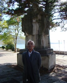 Carlos Oroza ante la escultura homenaje a los trovadores de la ría de Vigo, en la isla de San Simón. Foto: FISS