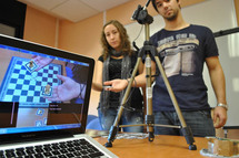 Los estudiantes Iván Paquico y Cristina Palmero muestran su innovador sistema de realidad aumentada para aprender a jugar al ajedrez.. Imagen: Universitat Politècnica de Catalunya.