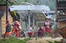 Niños jugando en una escuela de la aldea de Mambí al Oeste de Sulawsi, Indonesia. Al fondo una estación base de energía solar para teléfonos móviles. Fuente: ESA.