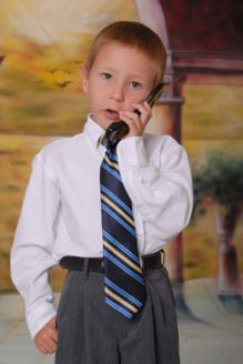 Un niño encorbatado hablando por teléfono. Imagen: Paul Moore. Fuente: PhotoXpress.