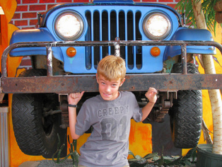 Un niño fingiendo que levanta un jeep. Imagen: wsilver. Fuente: Flickr.
