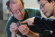Arto Nurmikko y su colaborador, Ming Yin, examinan su prototipo inalámbrico. Imagen: Fred Field. Fuente: Universidad de Brown.