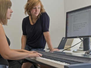 Anne Feit observa a una pianista aficionada tocar su "piano de escribir". Imagen: Jörg Pütz. Fuente: Instituto Max Planck de Informática.