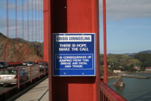 Cartel en el puente Golden Gate (California, EE.UU.) que advierte de las consecuencias de saltar por el puente y recomienda llamar a un teléfono de ayuda mediante un aparato situado allí mismo. Imagen: Miskatonic. Fuente: Wikipedia.