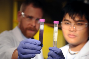 Dos investigadores, con un tubo contaminado (izquierda) y uno pendiente de análisis. Fuente: Georgia Tech.