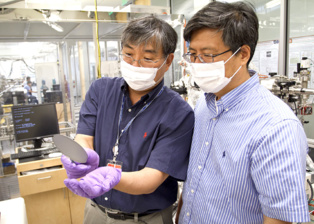 Jiyoung Kim (izda.) y Kyeongjae Cho examinan una placa utilizada para hacer transistores. Fuente: UT Dallas.