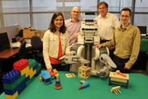 El equipo de investigación de la Universidad de California en Berkeley posa junto al robot BRETT. Fuente: Laboratorio de Aprendizaje Robótico en la UC Berkeley.