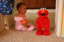 Un bebé con un muñeco Elmo. Imagen: Marc Levin. Fuente: Flickr.