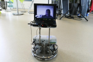 Desde su cama de hospital, un paciente discapacitado es capaz de controlar un robot a distancia y de interactuar con la gente que se encuentra a través de Skype. Imagen: Alain Herzog. Fuente: EPFL.