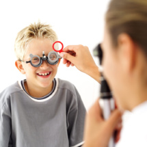 Profesional médico comprobando los ojos del niño ( 8-10). Imagen: © Royalty -Free/Corbis.