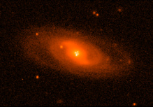 Imagen del sistema lente Q2237+0305 obtenida con el Nordic Optic Telescope en condiciones atmosféricas excelentes. Muestra la imagen de la galaxia espiral que hace de lente gravitatoria. Cerca del núcleo pueden verse las cuatro imágenes del cuásar producidas por el efecto. Imagen: Mediavilla et al. Fuente: UGR. Imagen del sistema lente Q2237+0305 obtenida con el Nordic Optic Telescope en condiciones atmosféricas excelentes. Muestra la imagen de la galaxia espiral que hace de lente gravitatoria. Cerca del núcleo pueden verse las cuatro imágenes del cuásar producidas por el efecto. Imagen: Mediavilla et al. Fuente: UGR.