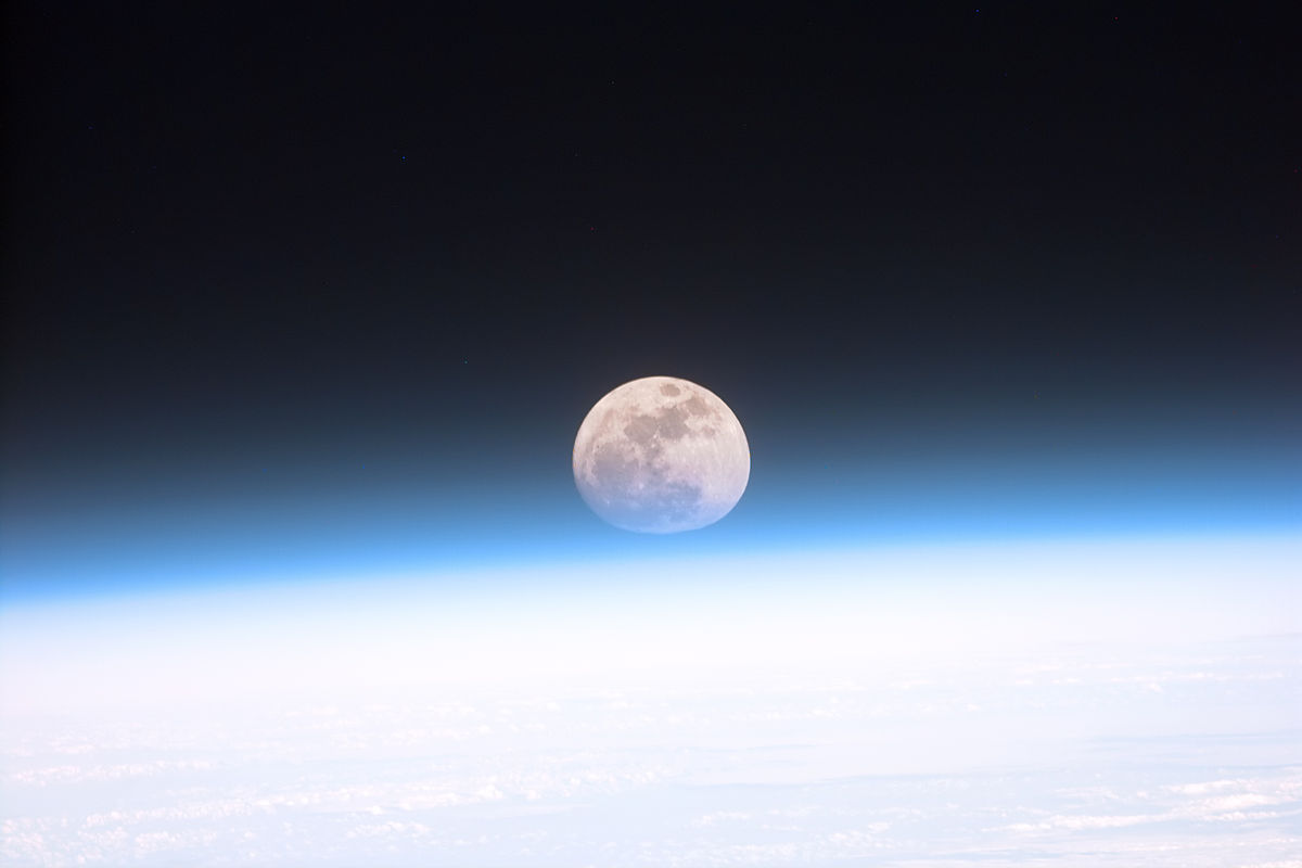 La atmósfera de la Tierra, captada por los astronautas del transbordador espacial Discovery en 1999, está siendo manipulada con fines militares. Al fondo se aprecia la Luna ligeramente distorsionada por el aire. Foto: NASA.