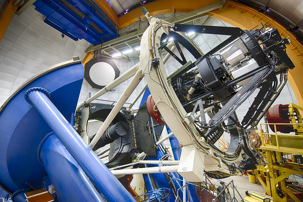Vista de la cámara DECam montada en el telescopio Blanco. El espejo principal del telescopio, visible frente a la cámara, tiene 4m de diámetro. La electrónica de la cámara, construida por CIEMAT e IFAE, se encuentra en el interior de las cajas de aluminoi de la parte superior. Crédito de la imagen: DES Collaboration y Fermilab.
