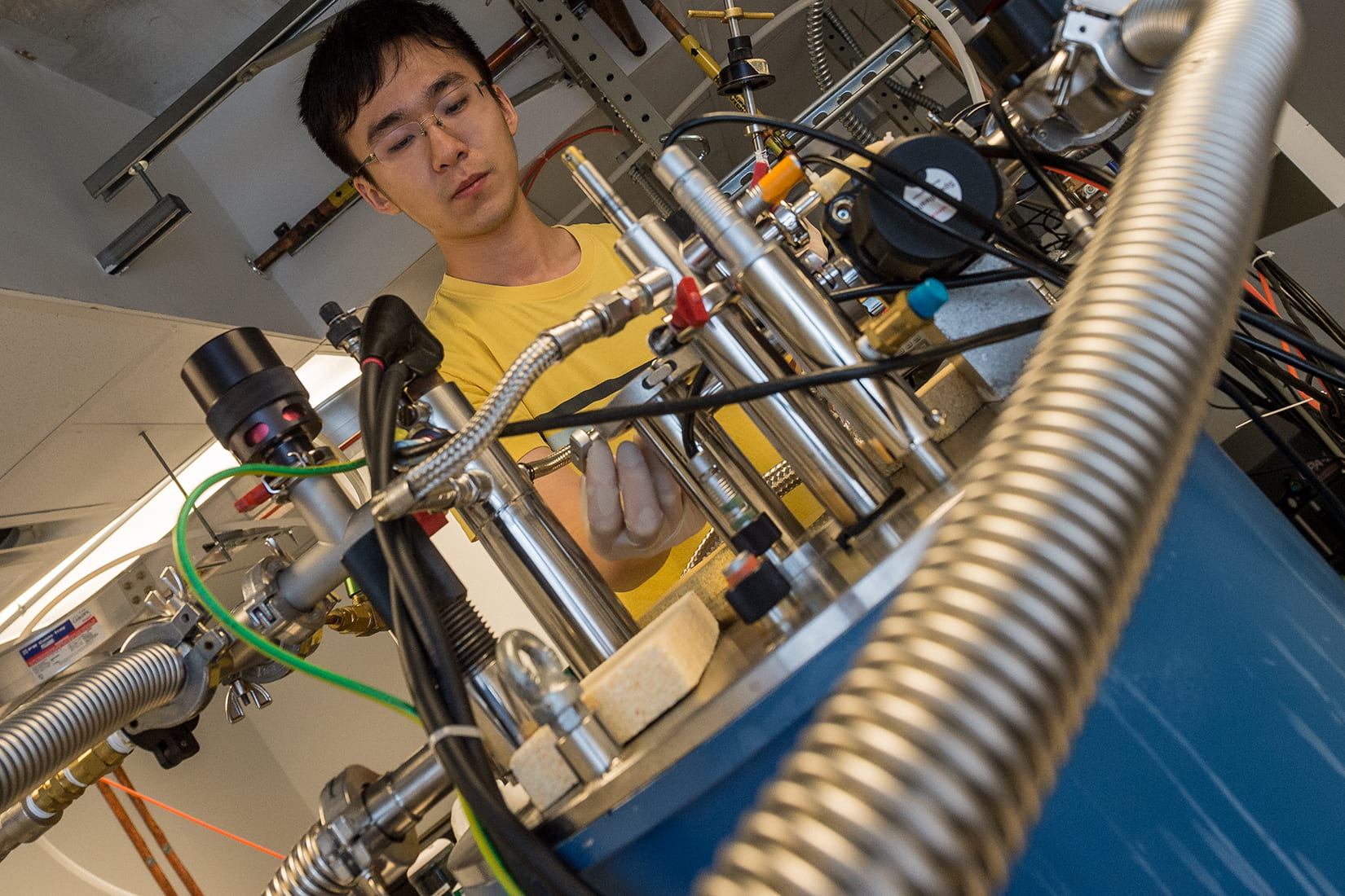 El investigador de la Universidad de Rice, Xinwei Li, con el espectrómetro de terahercios que luego utilizó para medir el entrelazamiento cuántico de los electrones que fluyen en el interior del metal raro. Foto: Jeff Fitlow/Rice University.