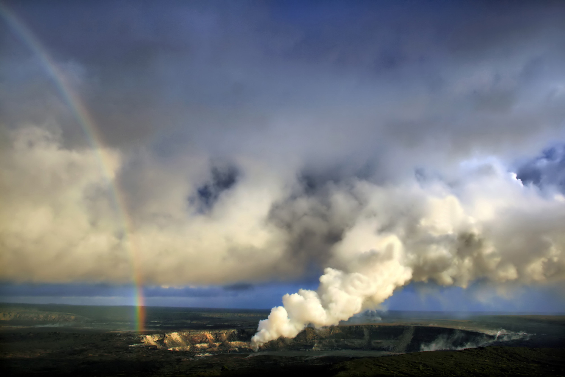 Arco iris y emisiones de dióxido de azufre con ceniza volcánica del cráter Halemaʻumaʻu, Kilauea. Foto: Brocken Inaglory.