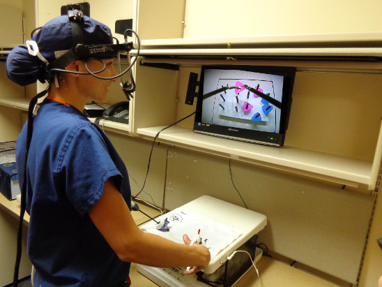 Una cirujana con el 'eye-tracker' (aparato de registro de movimientos oculares) en momentos previos a la realización de la tarea de simulación laparoscópica. Fuente: UGR.