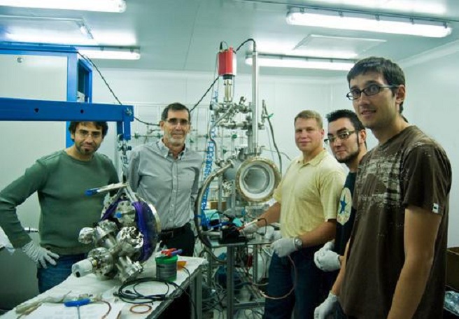 Juan José Gómez Cadenas (en el centro), con parte del equipo de NEXT ante un prototipo del experimento. Imagen: NEXT. Fuente: Sinc.