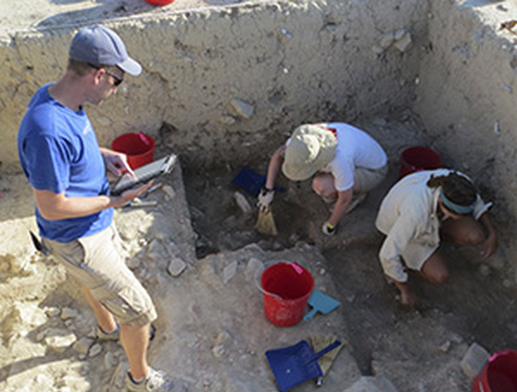Un estudiante toma notas en su iPad en Malloura mientras sus compañeros hacen trabajo de campo. Fuente: Jody M. Gordon/UWM