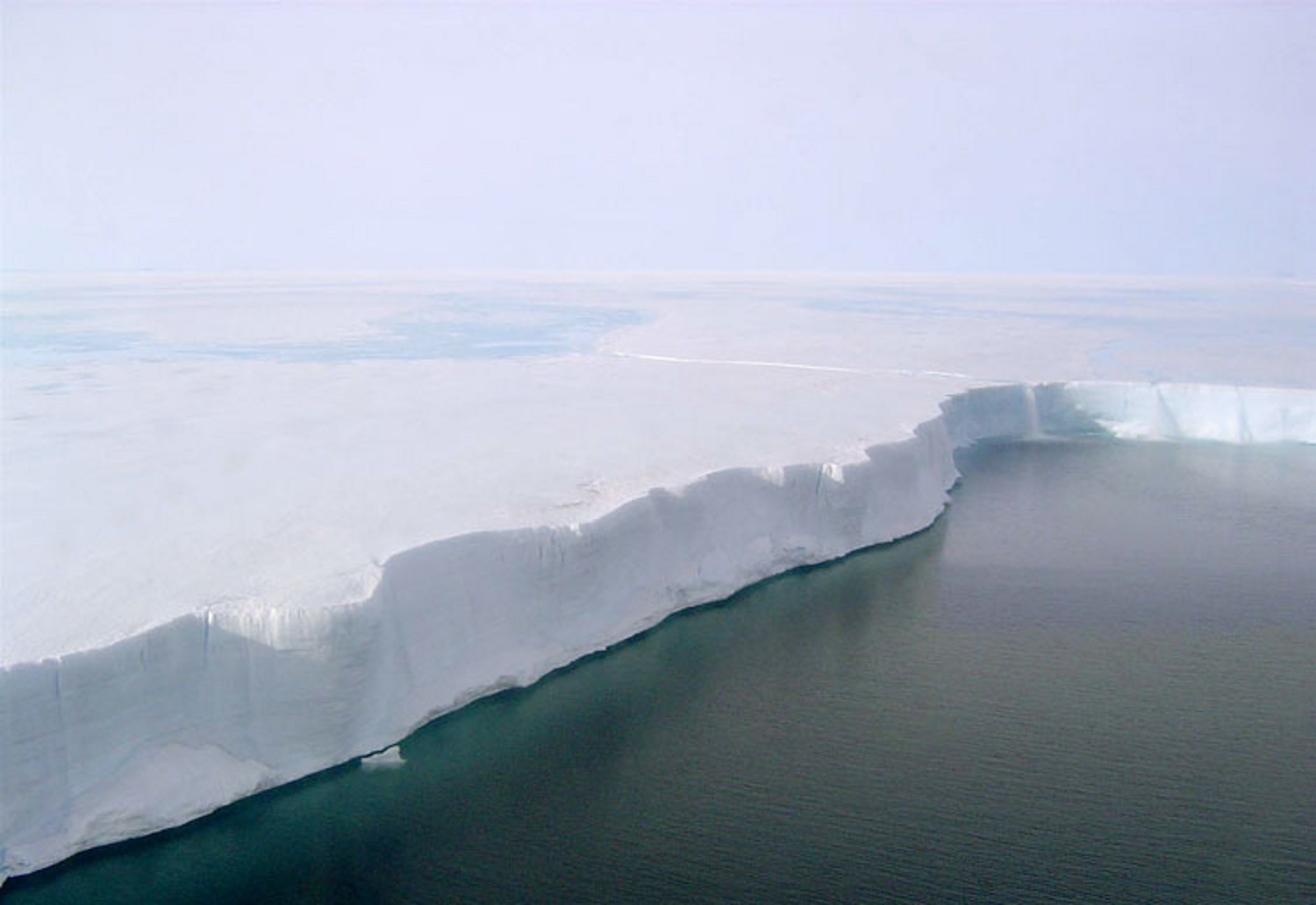 Borde de la plataforma de hielo Larsen B. El derretimiento de la superficie es visible y fluye por el borde como una cascada. Una nueva investigación proyecta una duplicación del deshielo de la superficie de las plataformas de la Antártida en 2050.. Fuente: Ted Scambos & Rob Bauer, NSIDC.
