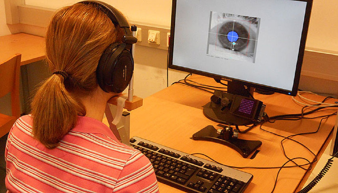 La investigadora Manuela Marín, delante del rastreador ocular, con un imagen de su pupila derecha en la pantalla. Imagen: Bruno Gingras. Fuente: Universidad de Viena.